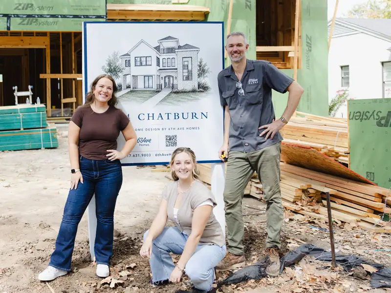 Three 6th Ave Homes team members at the company's yard sign in front of a framed new build
