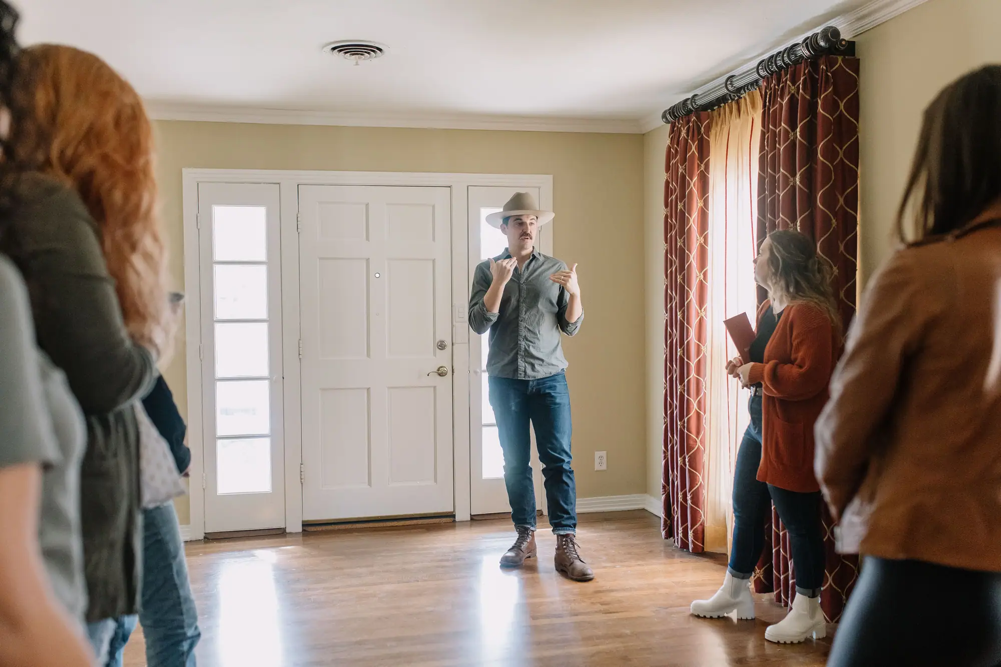 One of our team talks a group through an empty house with a wide front door and oak floors.