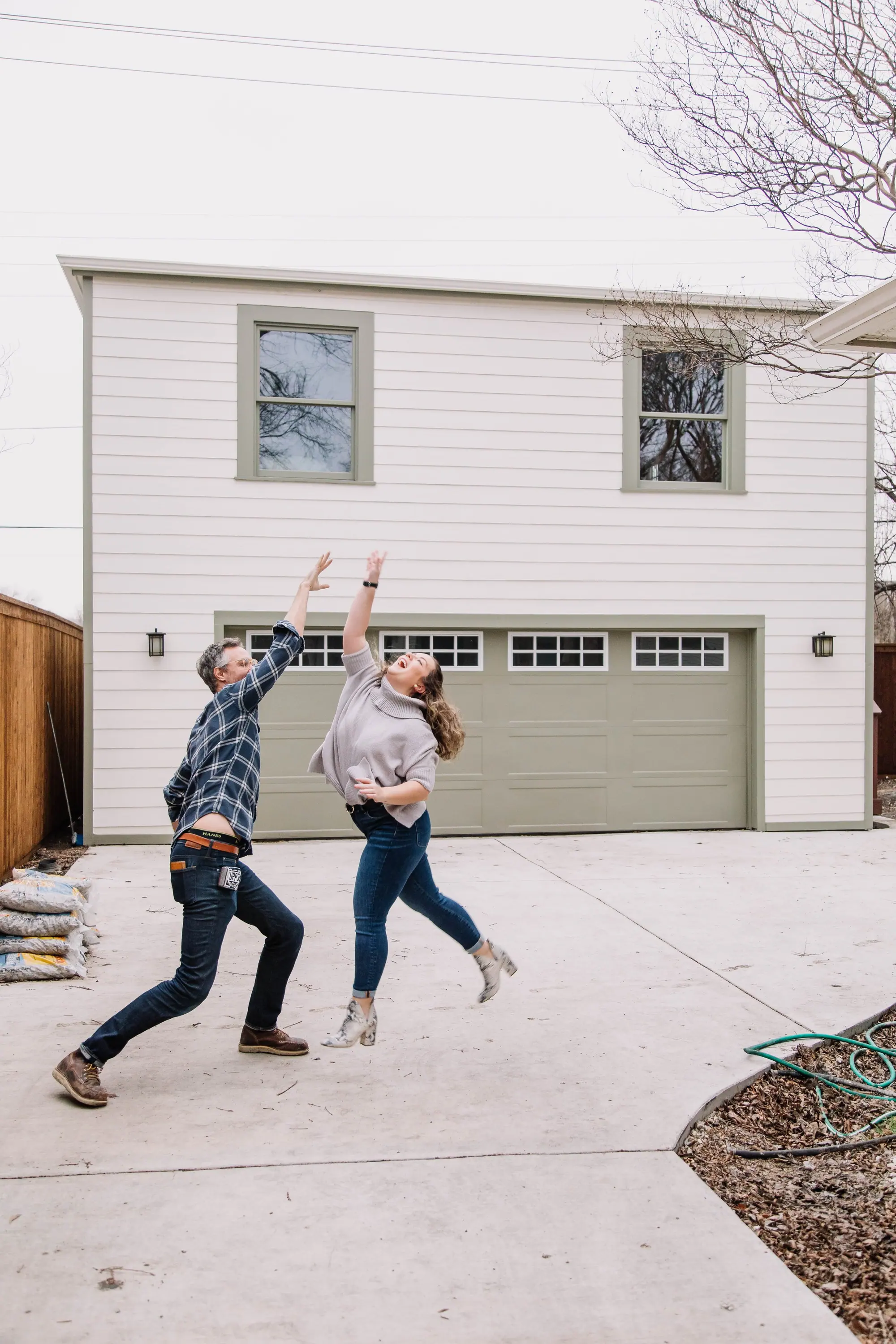 A Fort Worth family leaping in celebration in front of the home 6th Ave Homes just finished for them