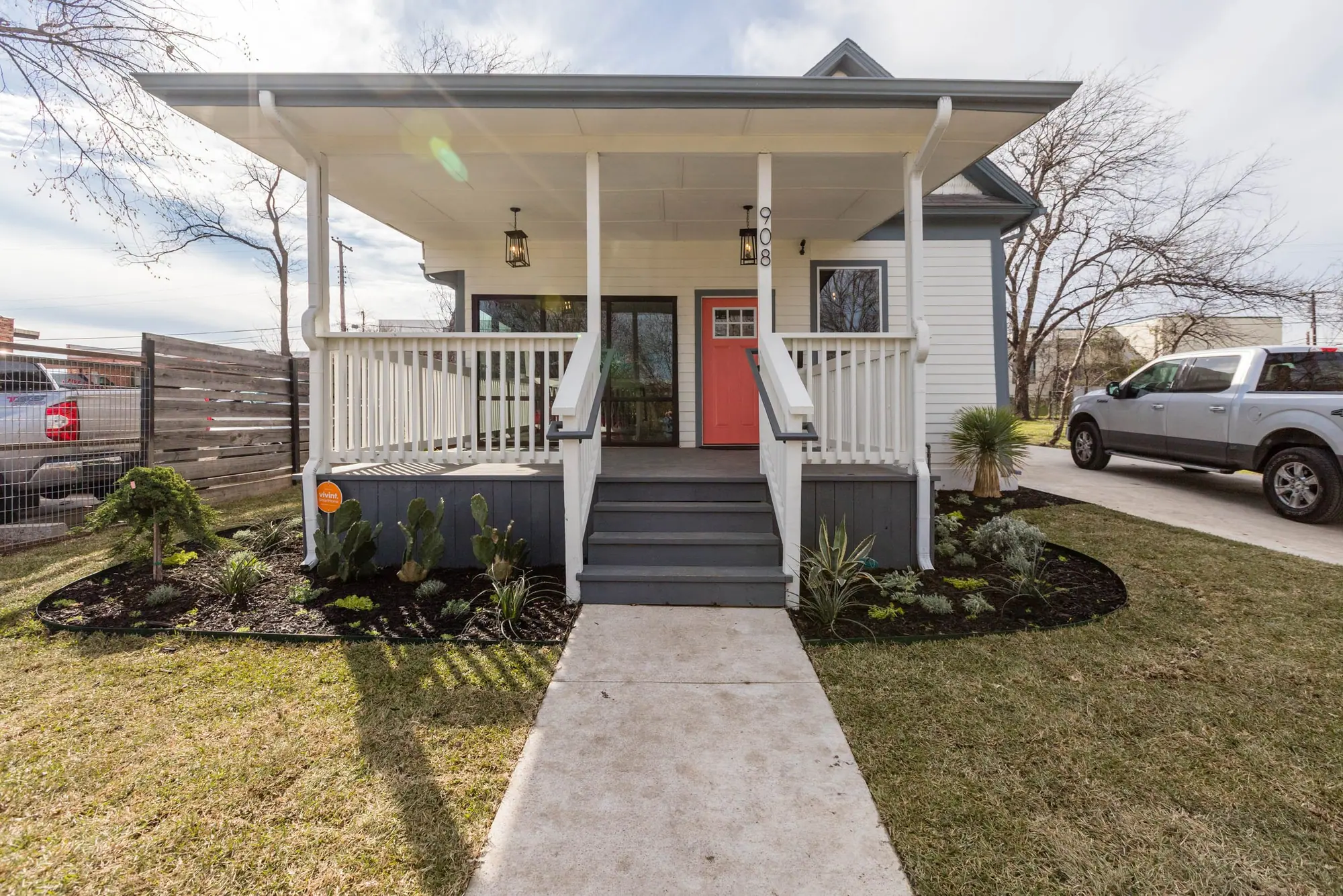 The 6th Ave Homes office, a white craftsman bungalow with a coral front door on Bryan Avenue, Fort Worth