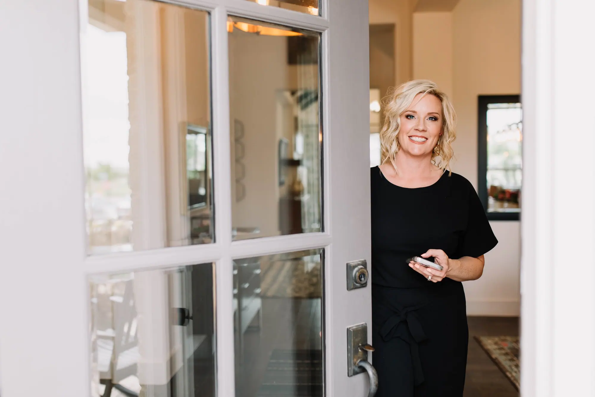 A 6th Ave Homes agent opening the front door of a home, welcoming you in