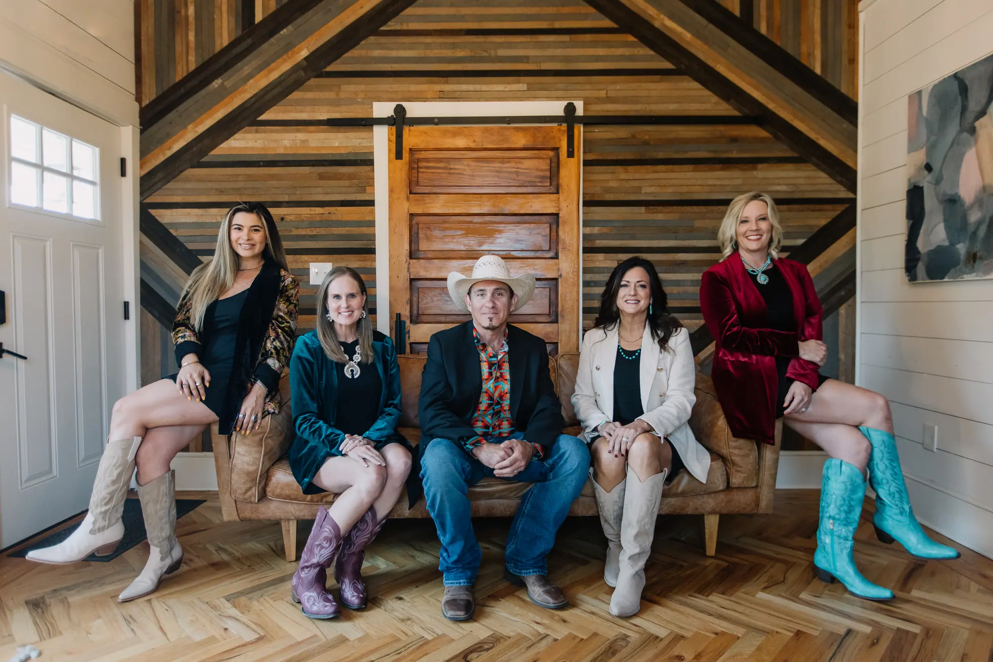 Five 6th Ave Homes agents seated together in a finished 6th Ave Homes renovation