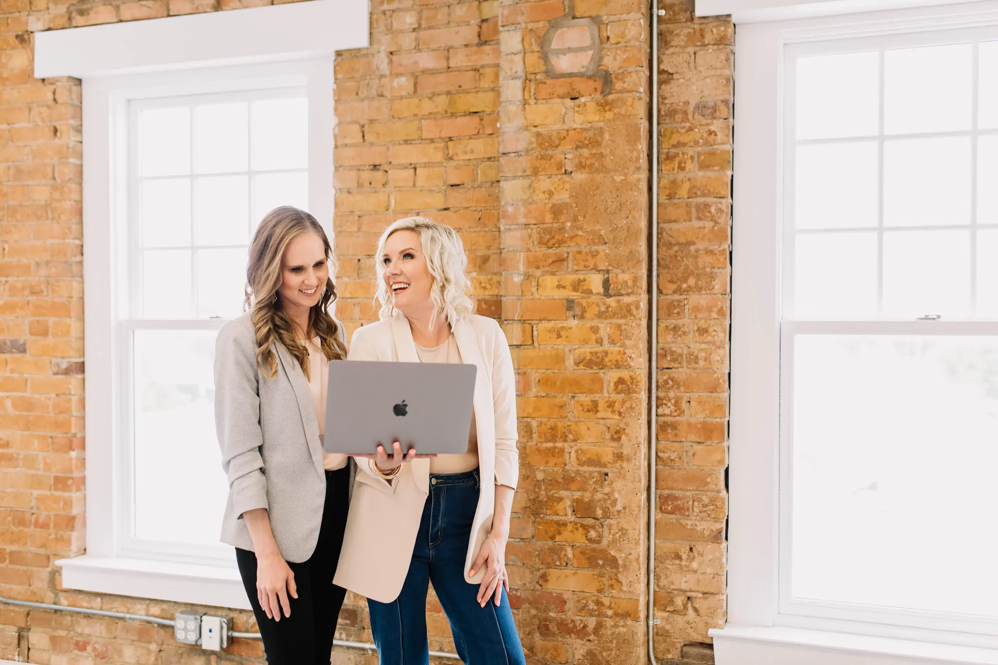 Two 6th Ave Homes agents going through a listing on a laptop together