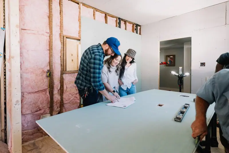 The 6th Ave Homes team reviewing garage apartment plans mid-build in Fort Worth