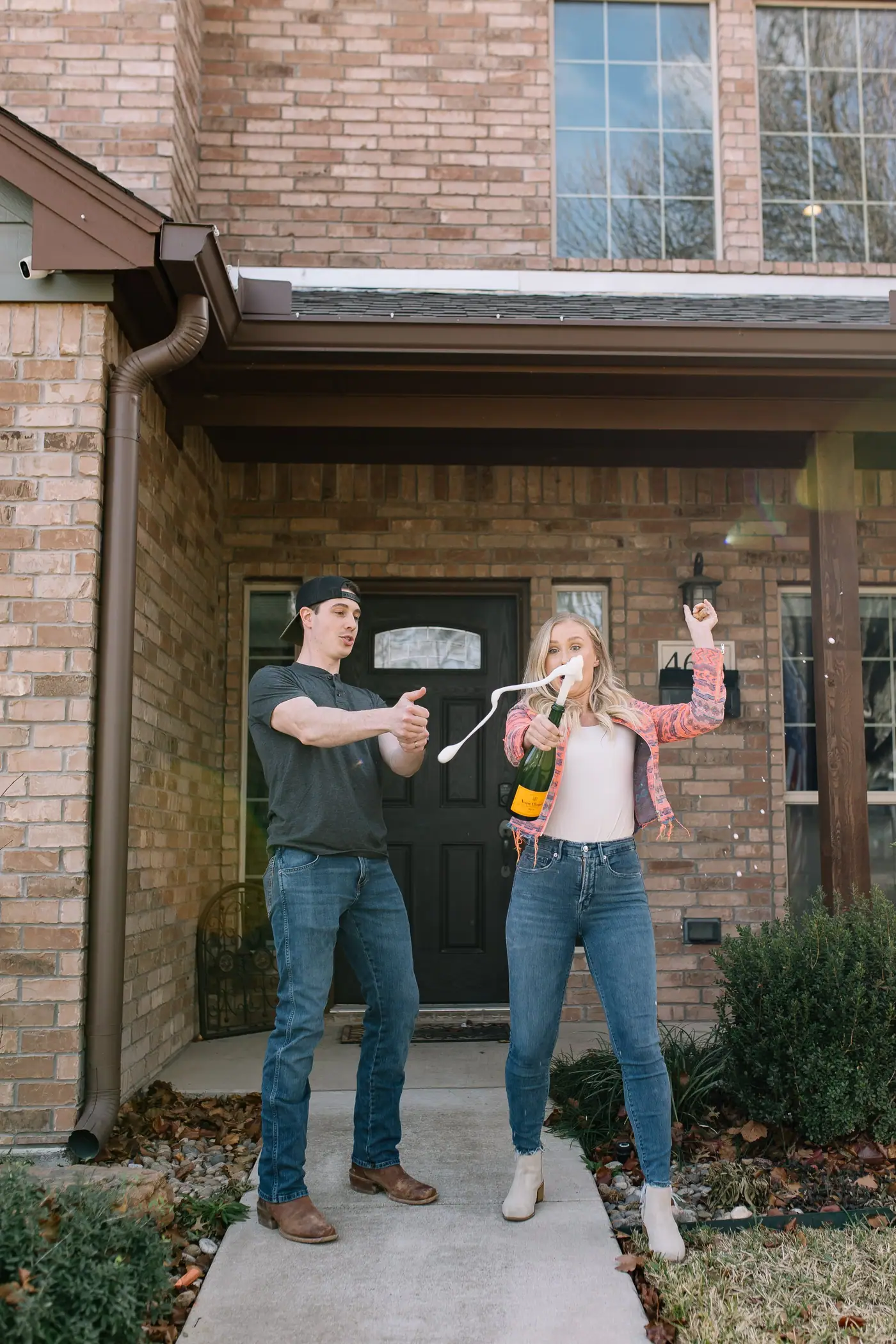 6th Ave Homes clients popping champagne on the front porch of their new Fort Worth home