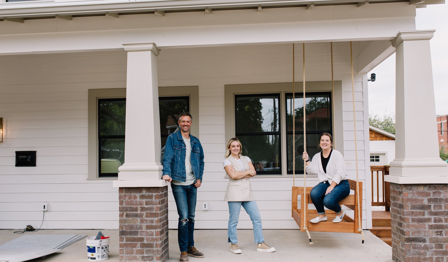Three members of the 6th Ave Homes team on the front porch of a custom home they built in Fort Worth