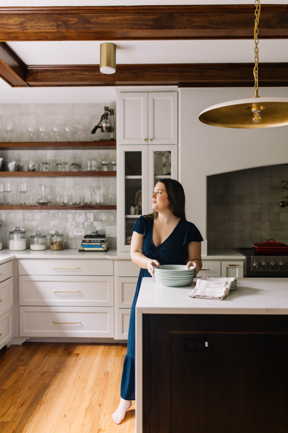 A thoughtfully space-planned Fort Worth kitchen with open shelving, a marble island, and brass lighting designed by 6th Ave Homes