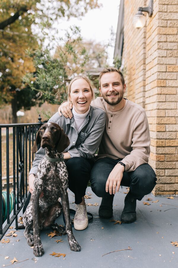 A 6th Ave Homes couple celebrating with their dog on the front porch of their new home