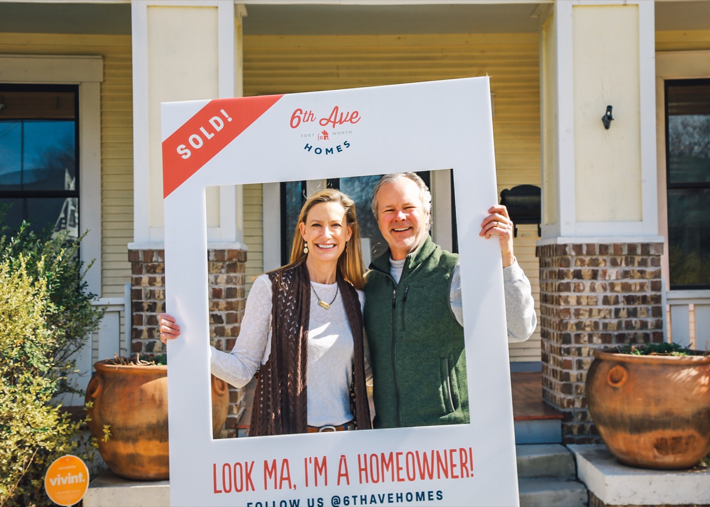 Fort Worth homeowners celebrating behind a 6th Ave Homes ‘Look Ma, I'm a homeowner’ sold frame