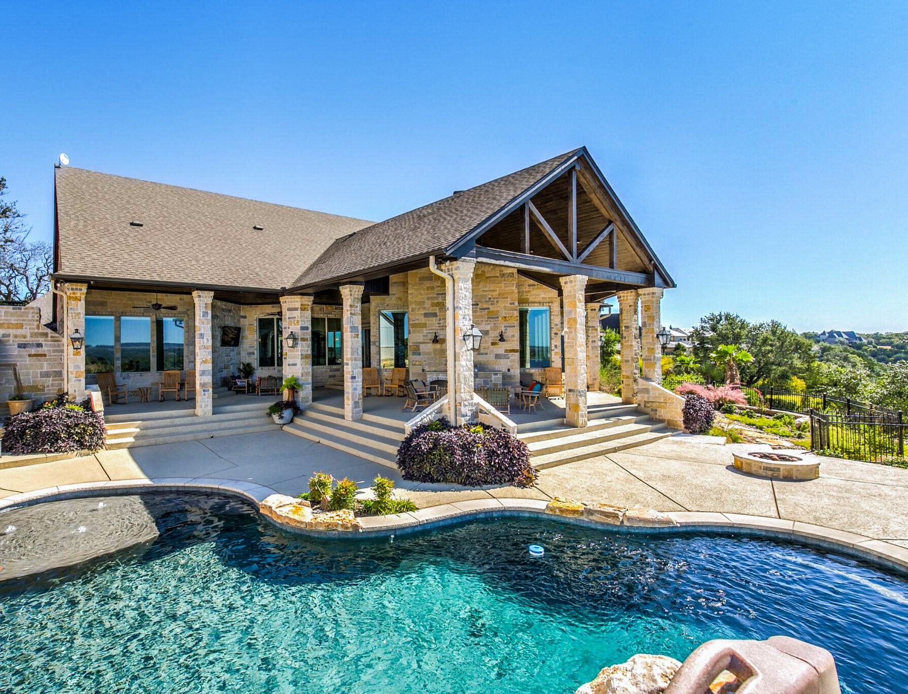 A grand stone estate with a resort-style pool and Hill Country views