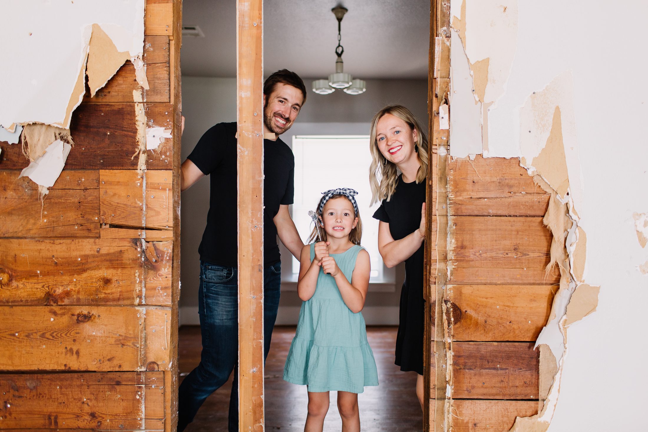 A Fort Worth family looking through a wall opened down to the original shiplap and studs during their whole-home remodel