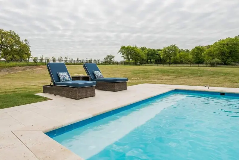 A bare rectangular pool sitting alone in an empty yard: no shade, no kitchen, no living space