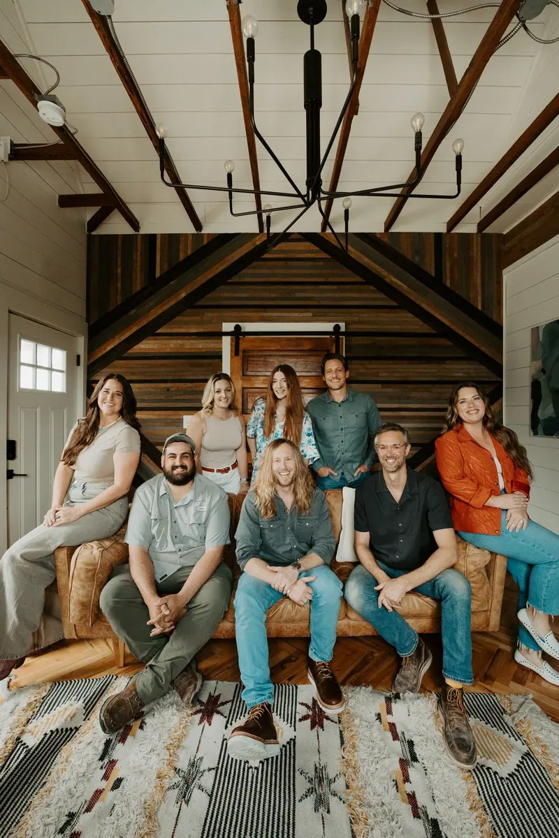 The 6th Ave Homes team together on the office leather couch