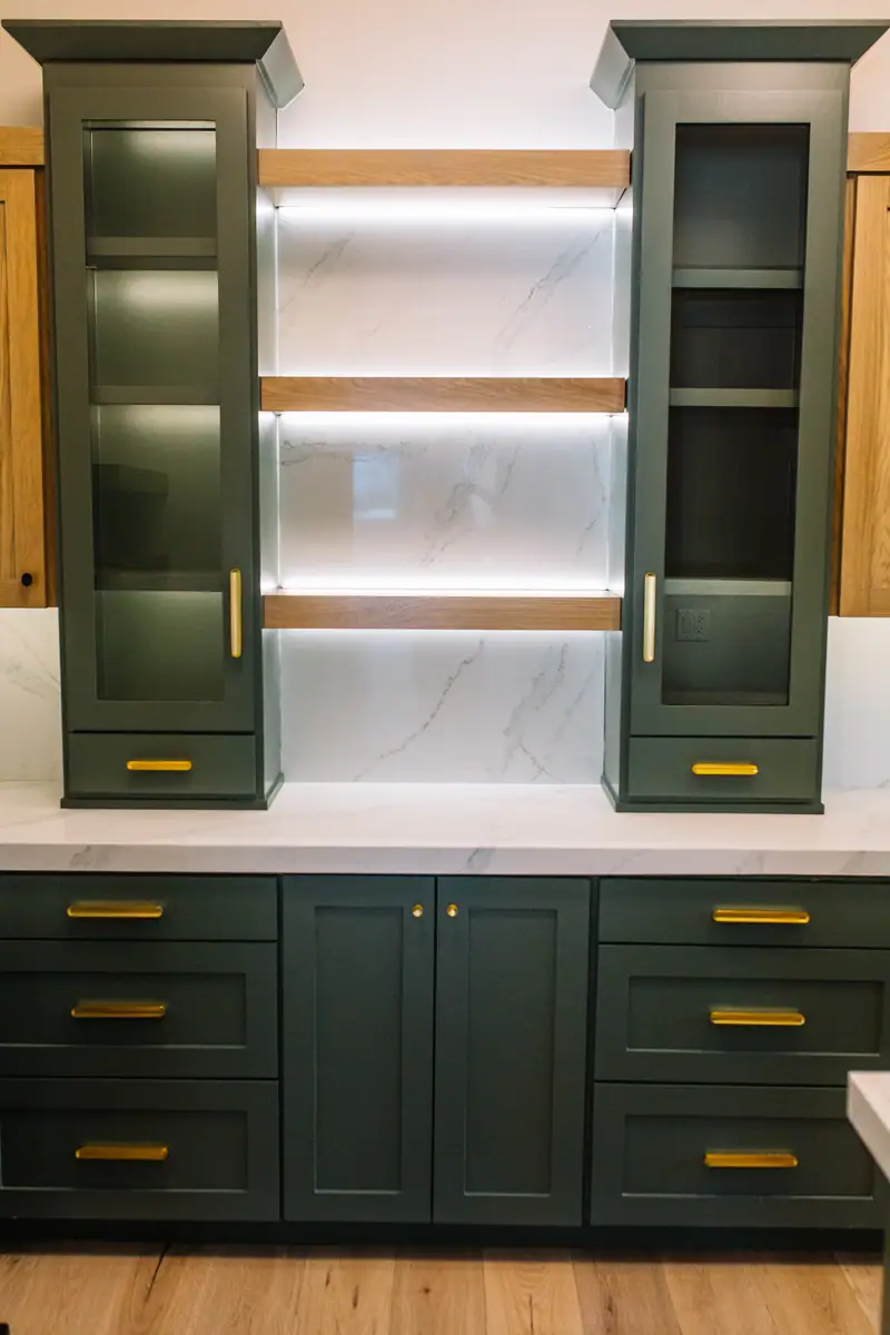 Lit glass-front cabinetry with reeded glass doors above a Calacatta quartz counter