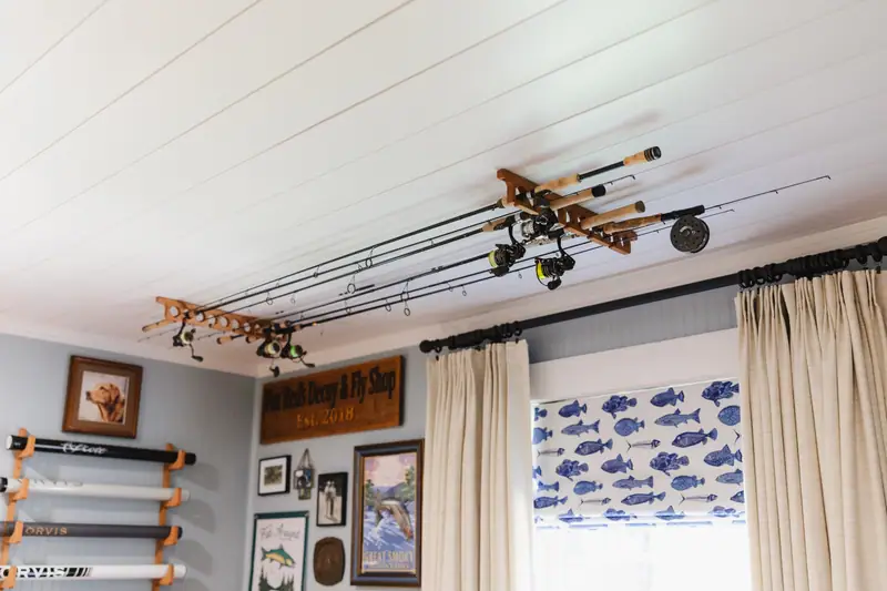 Ceiling- and wall-mounted fly-rod storage above the gallery wall and the fish-inspired Roman shade