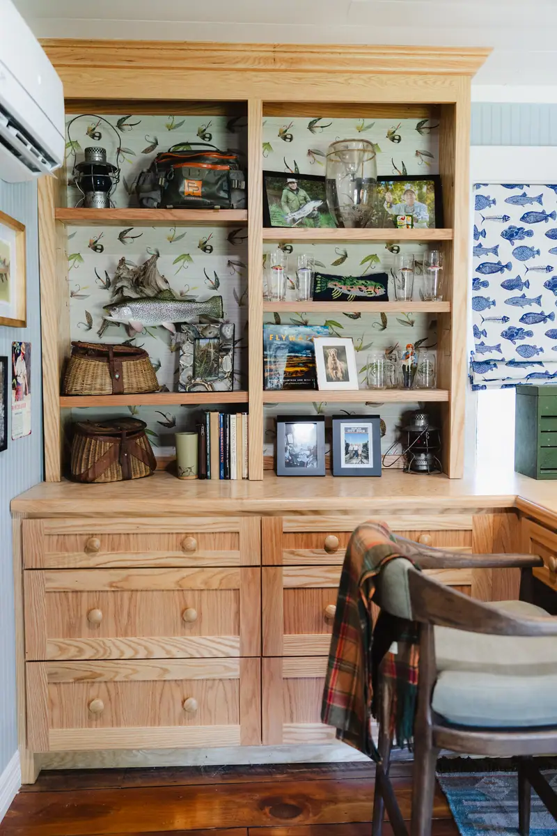 Custom built-in cabinetry with deep drawers and open shelving, backed with fish-inspired wallpaper