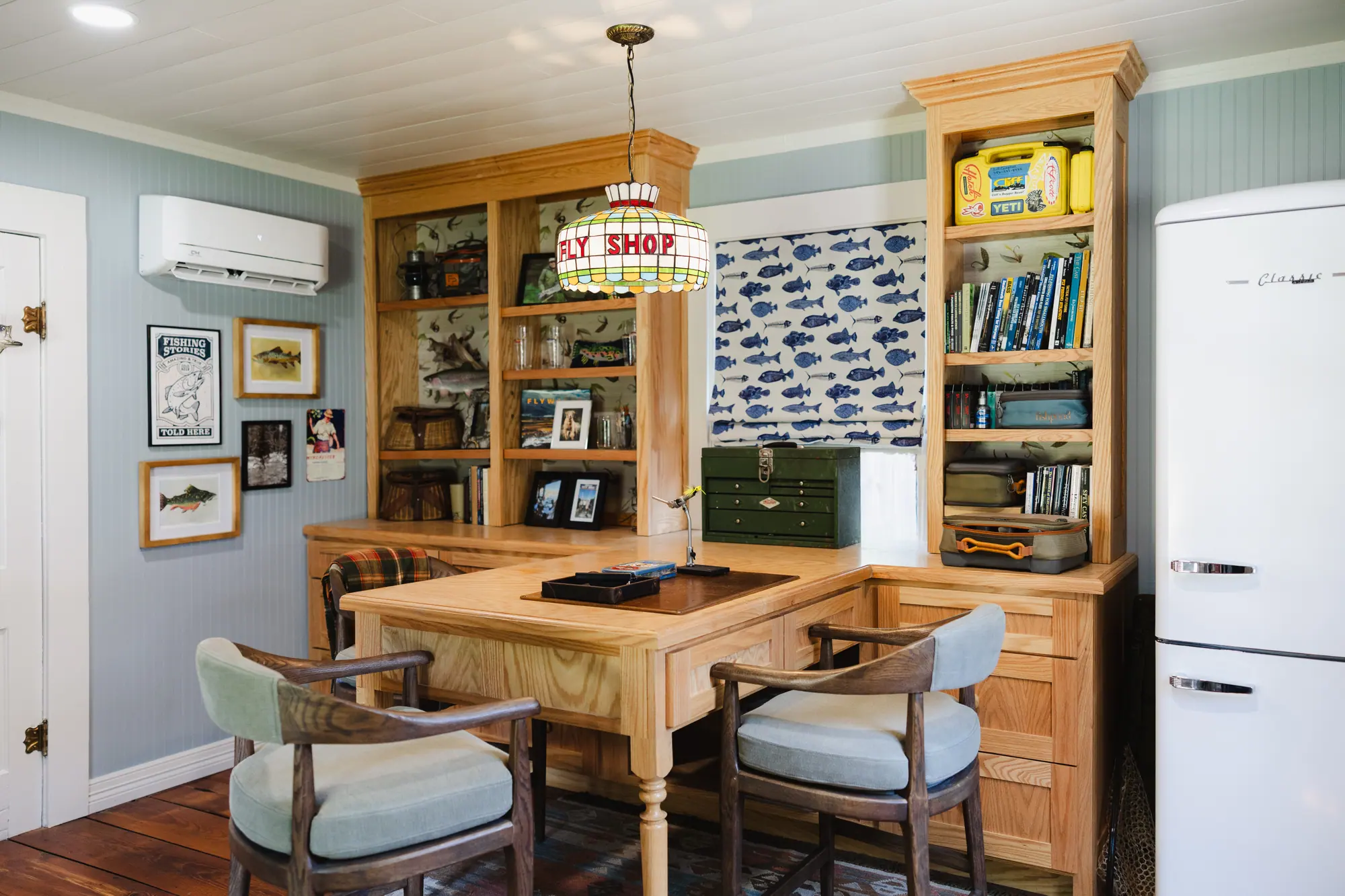 The Fly Shop interior with custom built-ins, the furniture-style fly-tying peninsula, the stained-glass Fly Shop chandelier and a vintage refrigerator