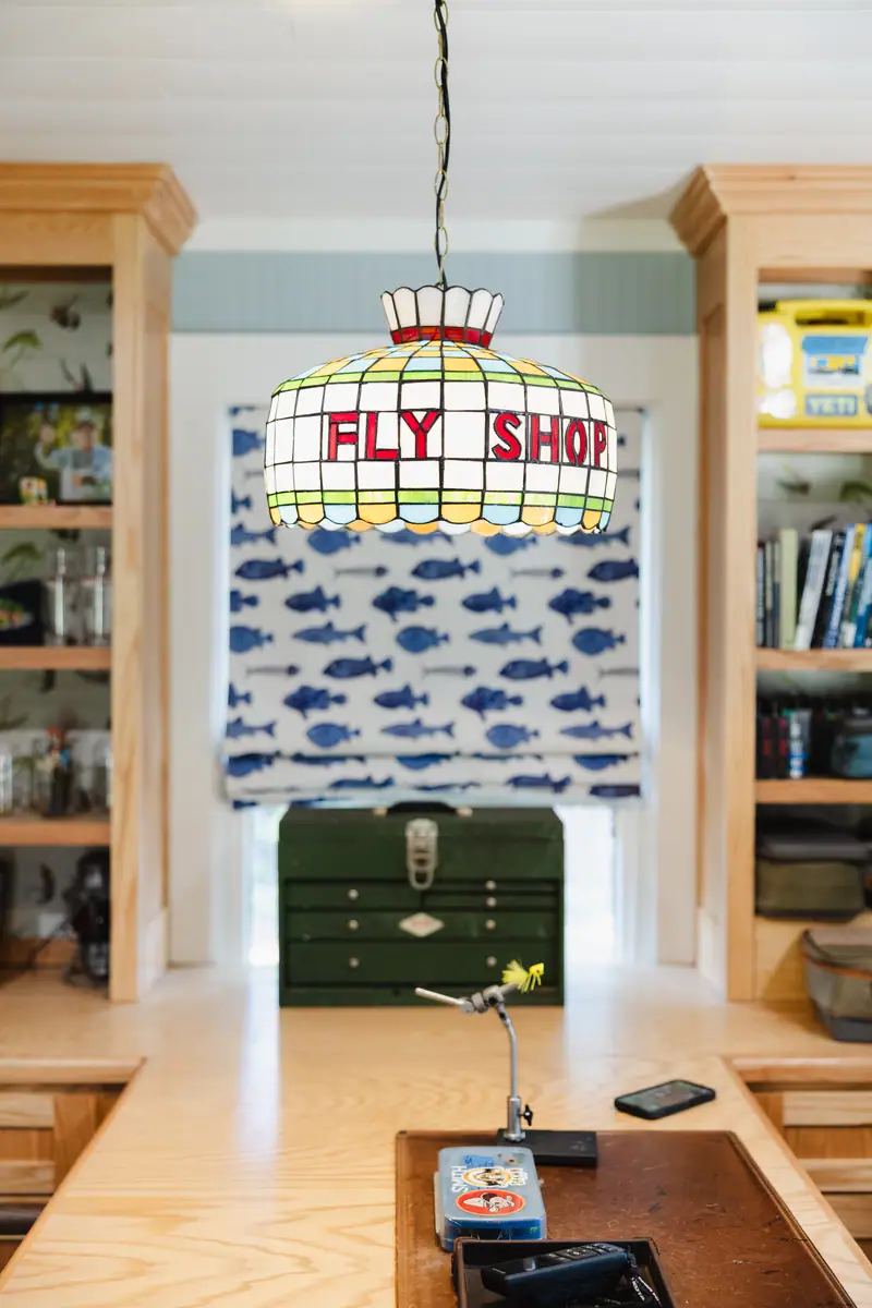 Custom stained-glass Fly Shop chandelier over the peninsula, with the fish-inspired Roman shade behind it