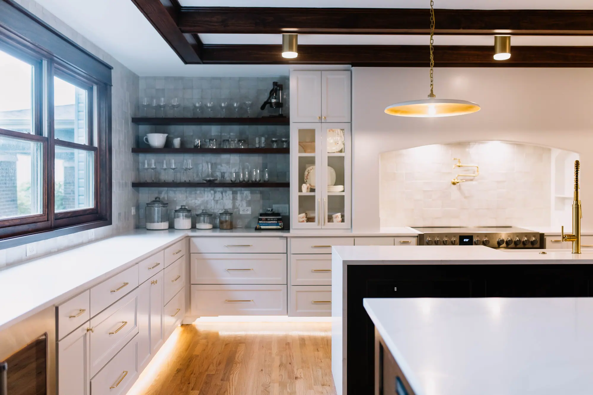 Ryan Place Historic Addition: the kitchen, with a stained beam ceiling, dark-stained open shelves, an arched range alcove and a dark-stained second island